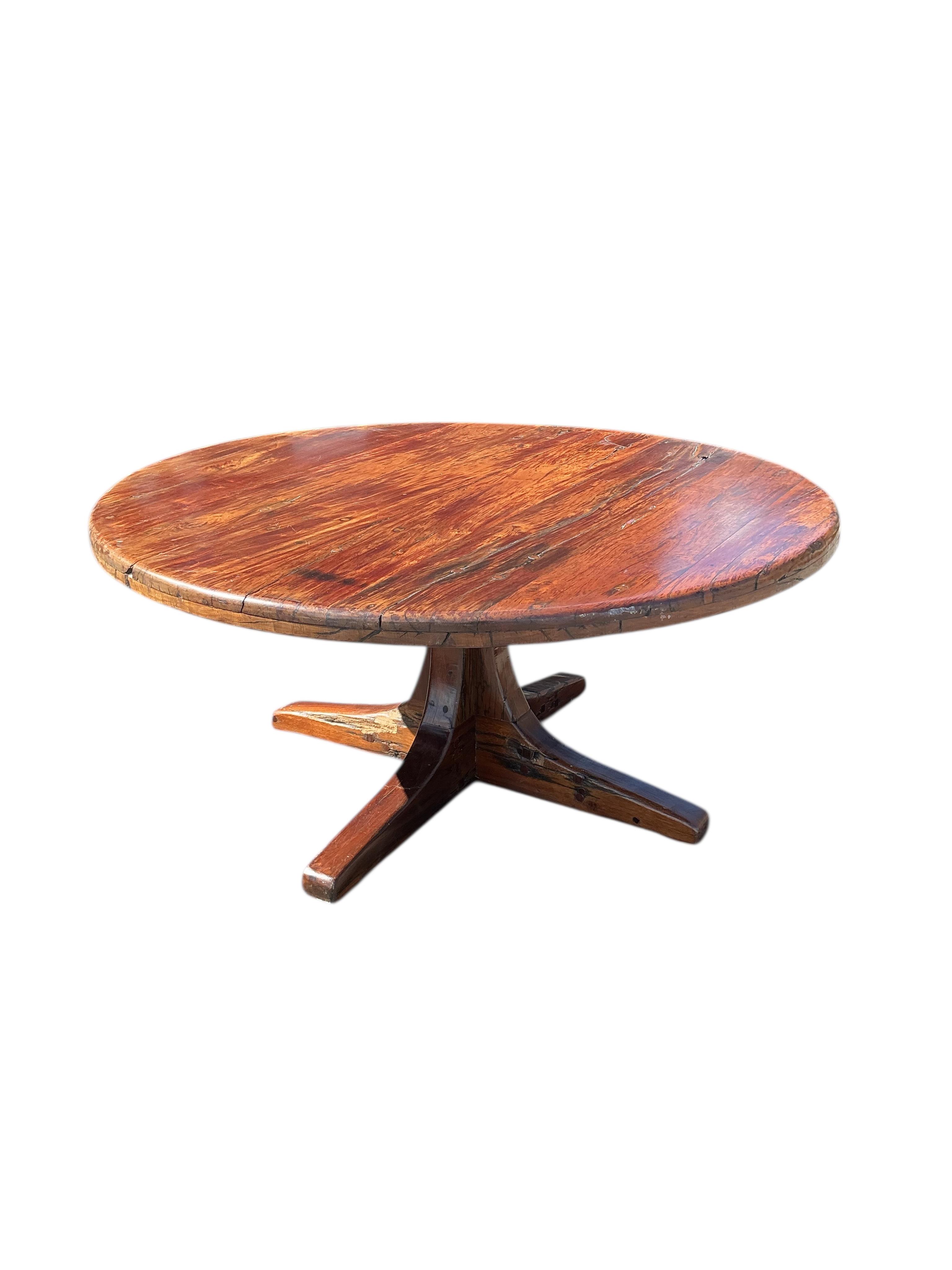 A Zimbabwean reclaimed Jarrah railway sleeper hardwood circular pedestal dining table, diameter 170cm, height 75cm and eight chairs by Rail Antiques, Harare, each piece stamped Rail Antiques